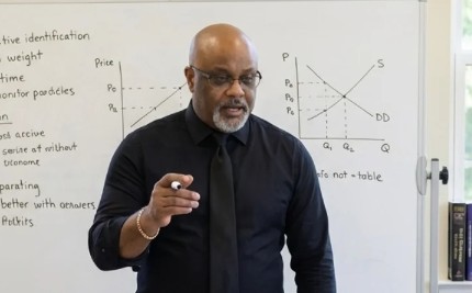 Dr. Boyce Watkins teaching financial concepts at a whiteboard — live daily training on wealth building